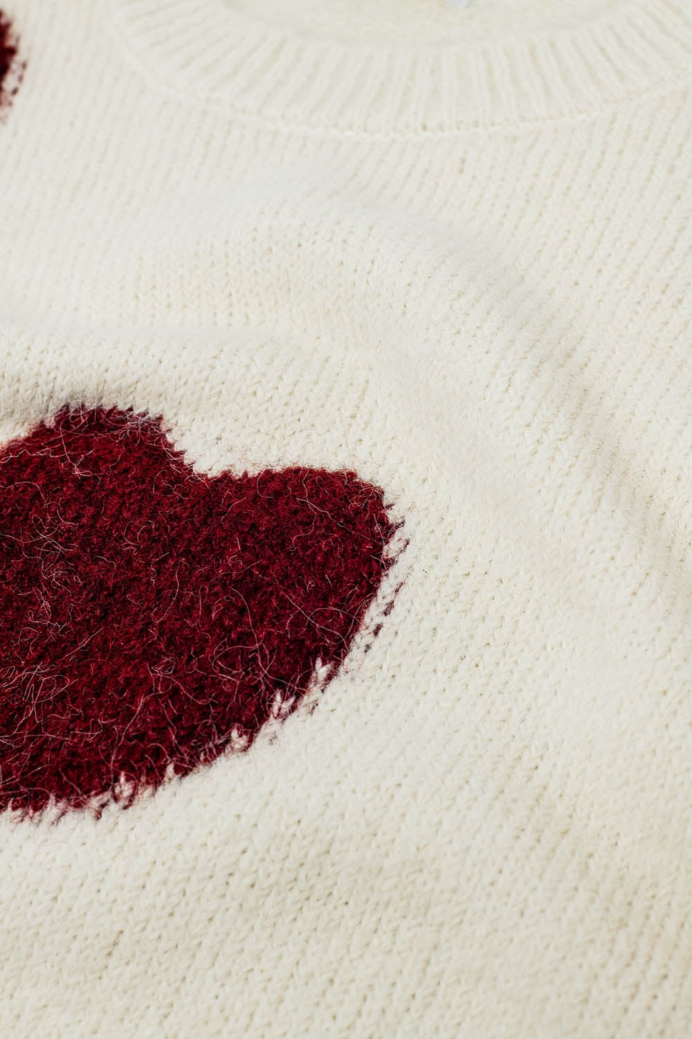 acogedor suéter blanco con corazones rojos