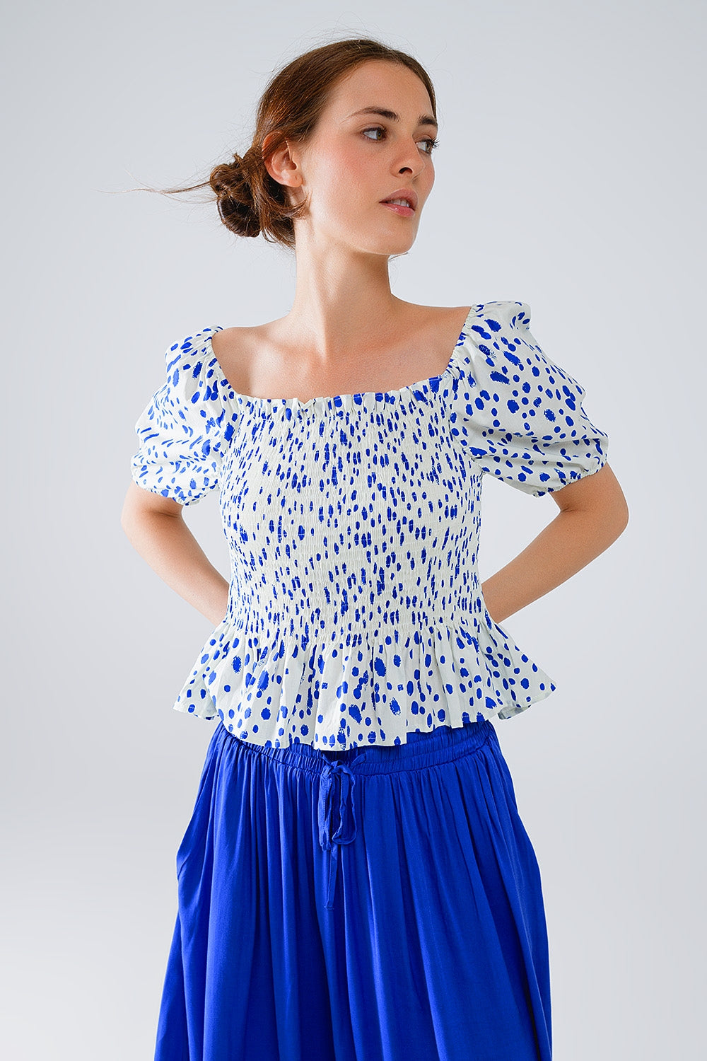 Blusa blanca con pliegues y lunares azules