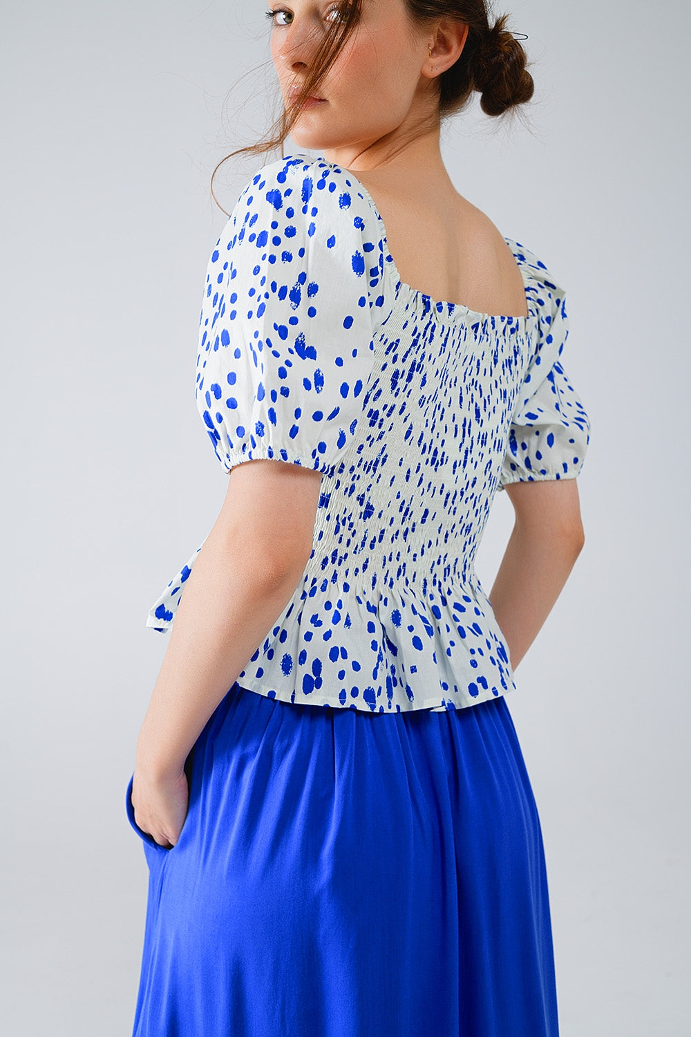 Blusa blanca con pliegues y lunares azules
