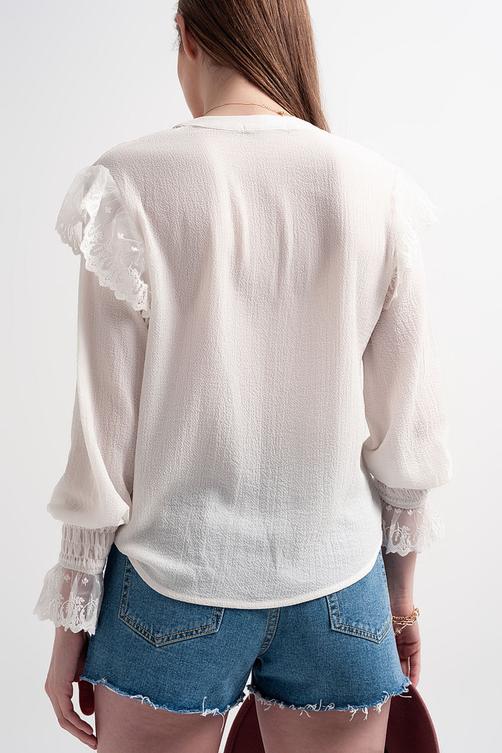 Blusa con volumen en las mangas y volantes en los puños en color crema