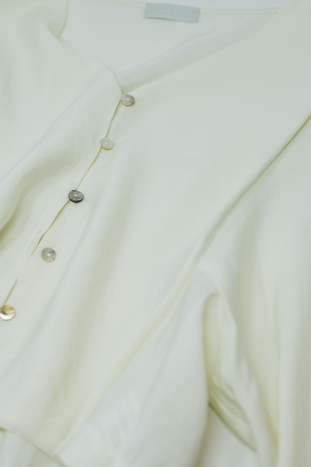 Blusa crema con mangas globo y cierre frontal con botones