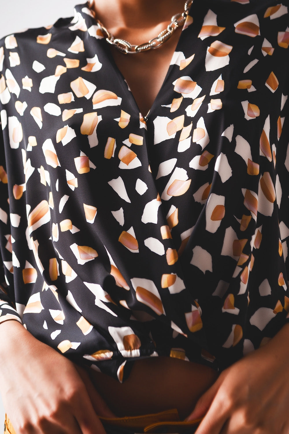 Blusa negra con estampado y parte delantera cruzada