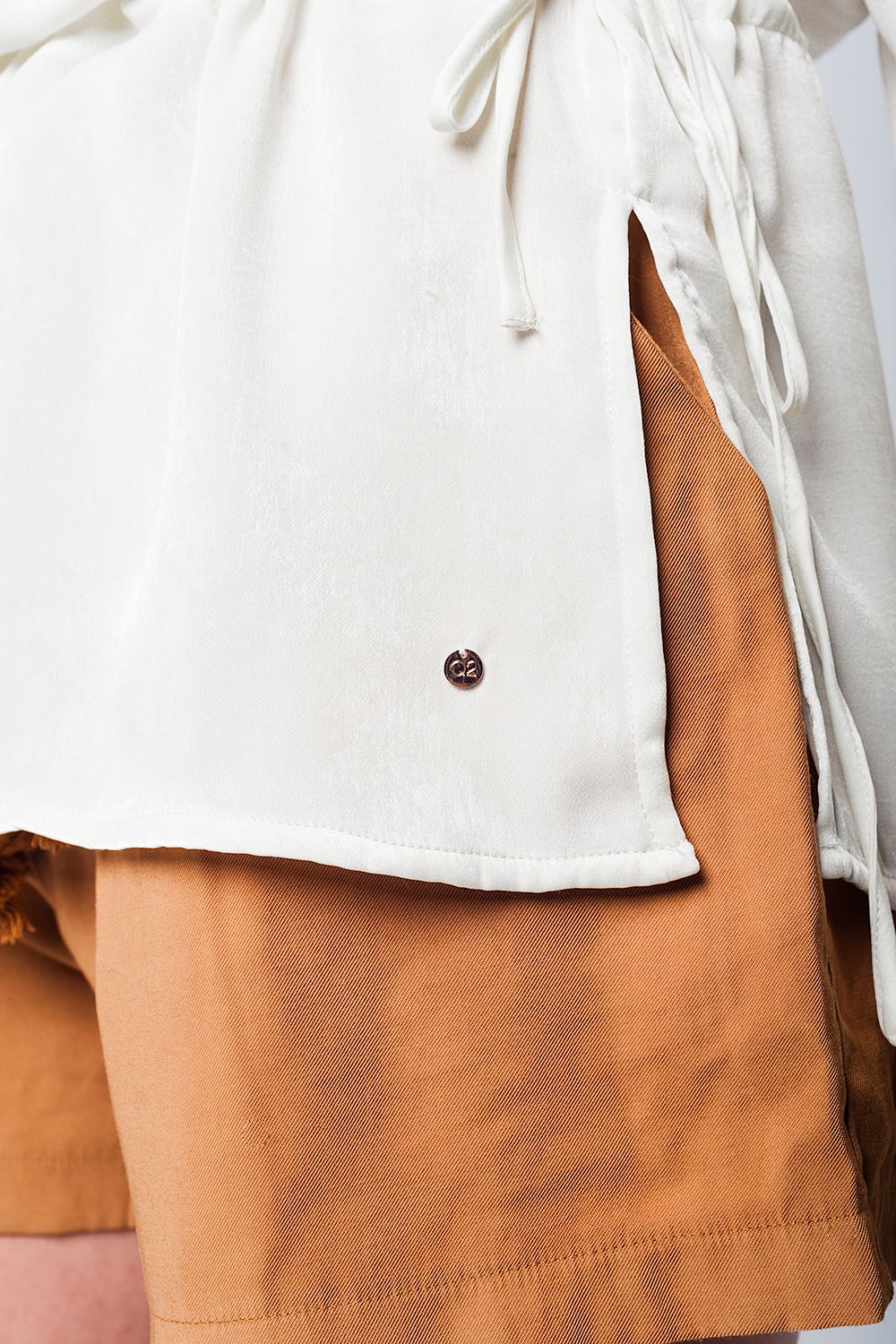 Blusa suave beige con volante y cinturón