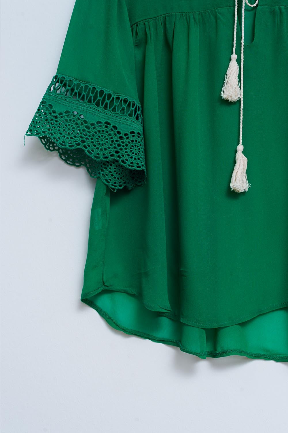 Blusa verde con lazadas en la parte delantera y bordados
