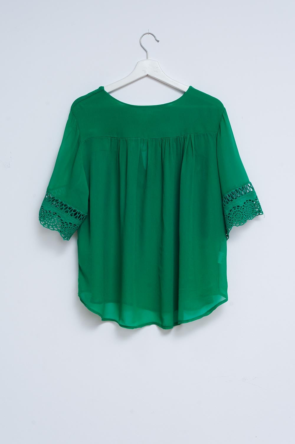 Blusa verde con lazadas en la parte delantera y bordados