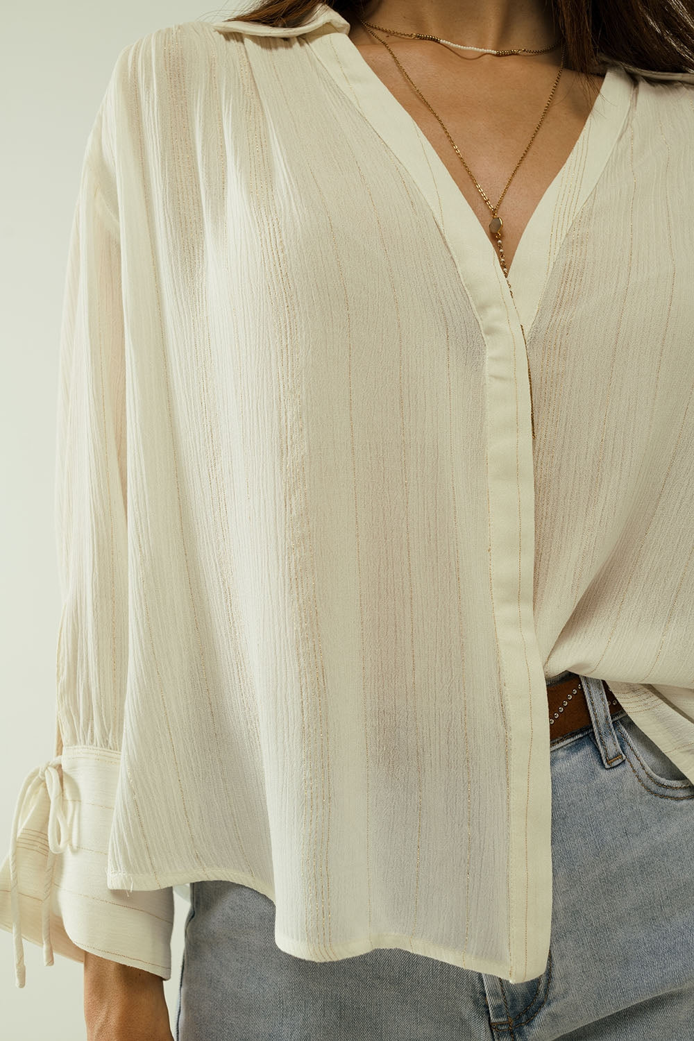 camisa blanca ligera con cuello de pico y detalles de rayas