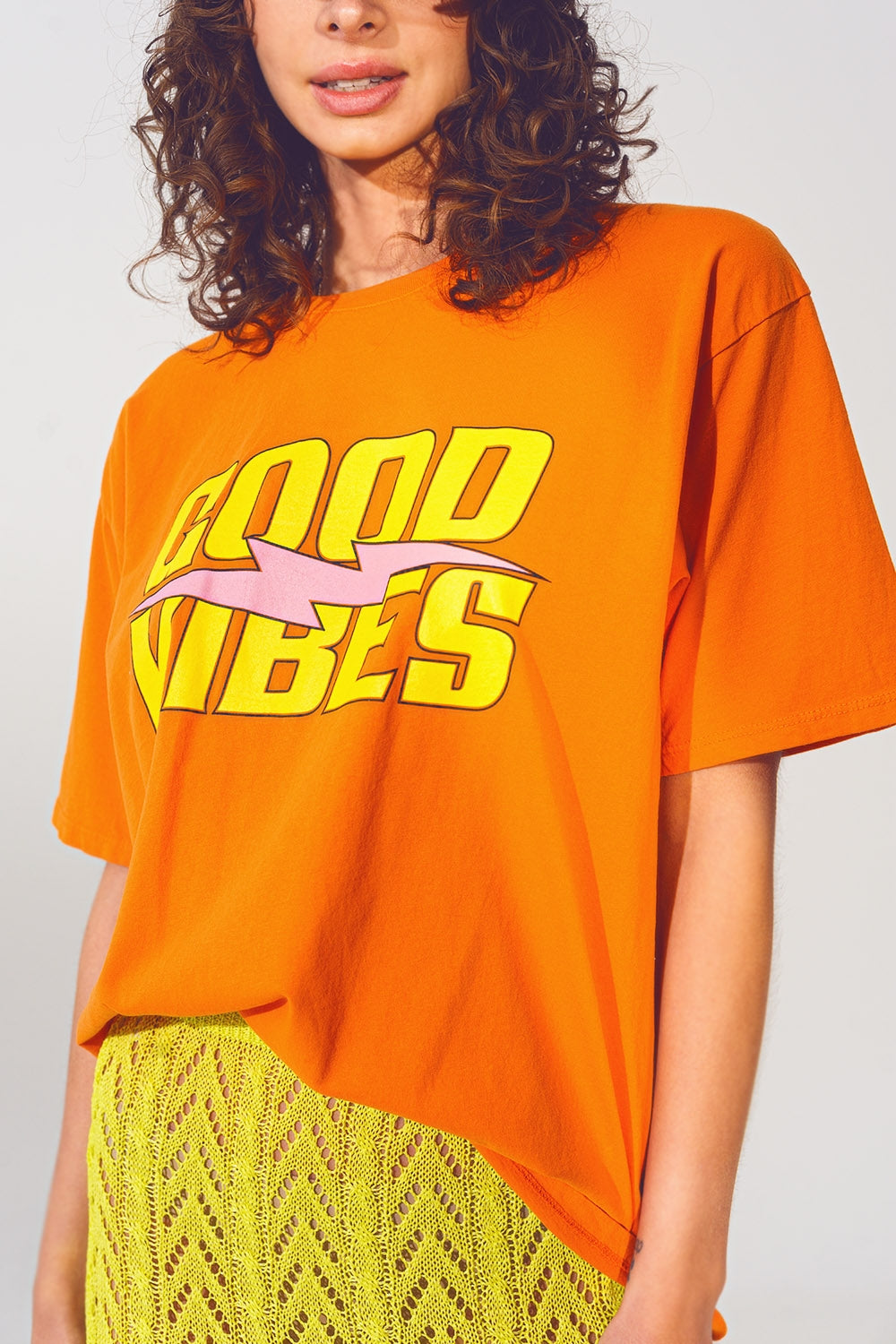 Camiseta con texto Good Vibes en naranja