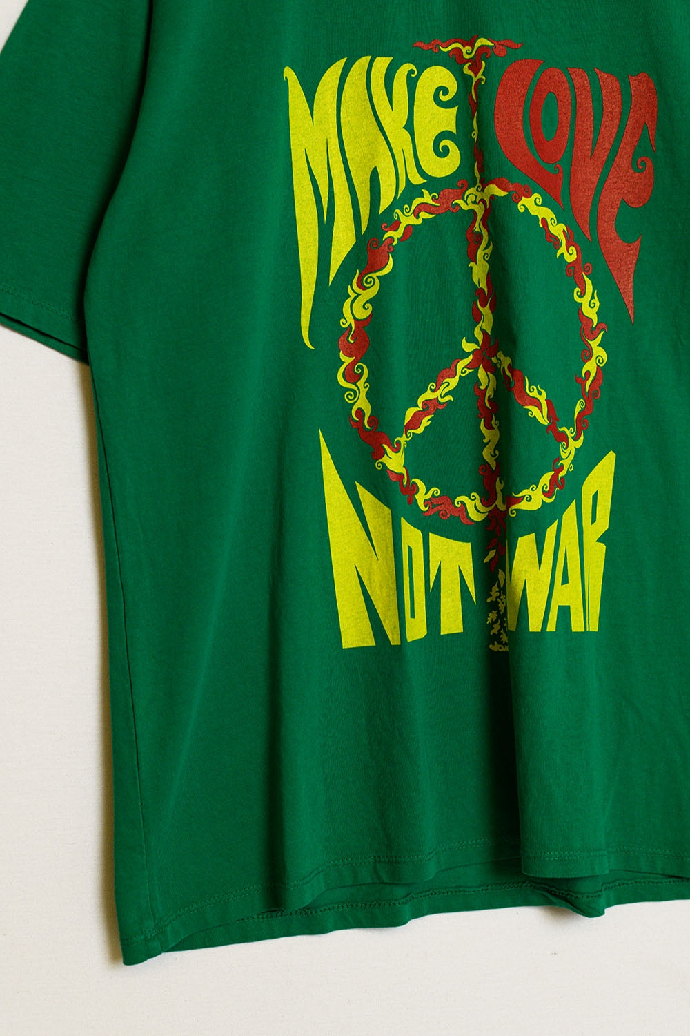 camiseta verde de manga corta con el logotipo Make love not war