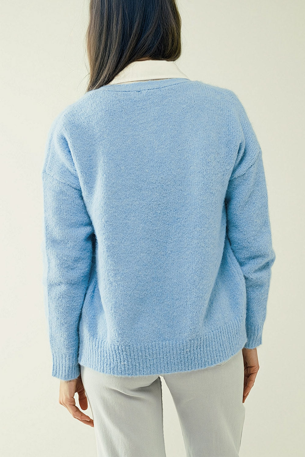 Chaqueta de punto azul con cuello de pico ancho y cierre de botones