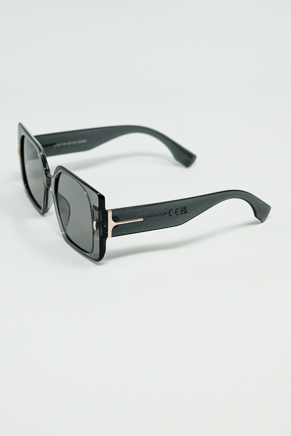 Gafas de sol cuadradas grises con detalle dorado en el lateral