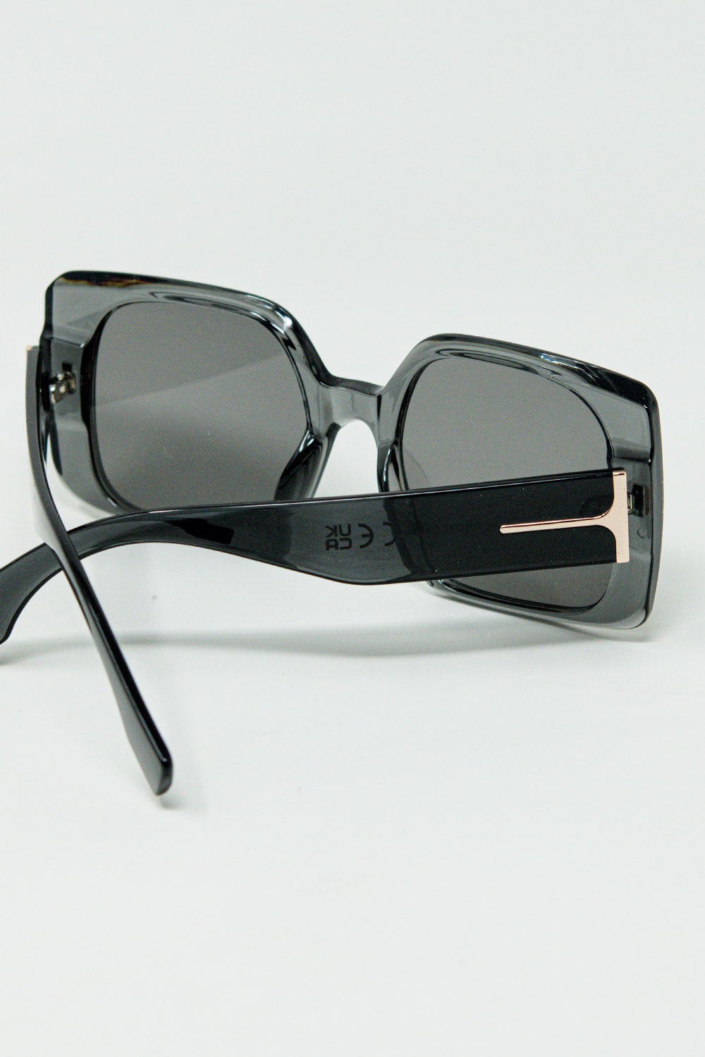 Gafas de sol cuadradas grises con detalle dorado en el lateral