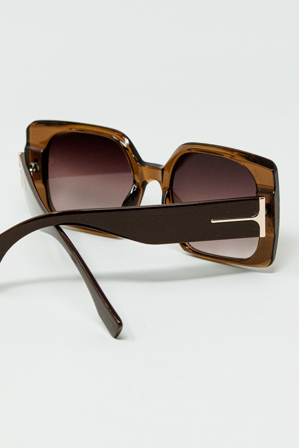 Gafas de sol cuadradas marrones con detalle dorado en el lateral
