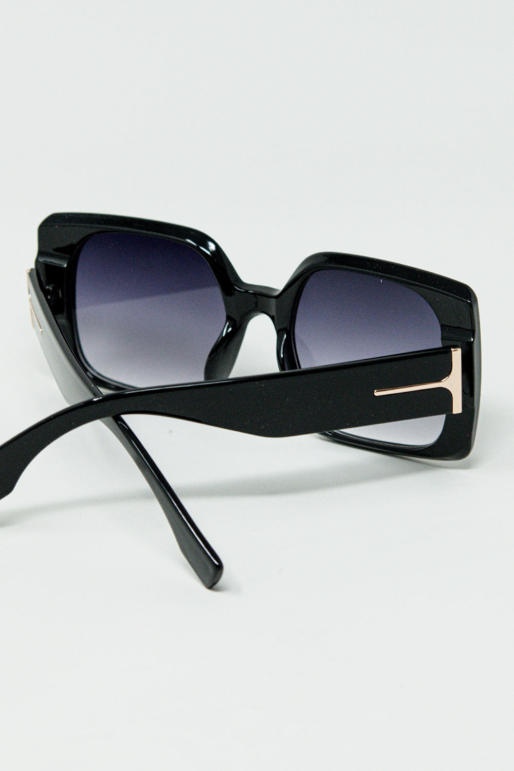 Gafas de sol cuadradas negras con detalle dorado en el lateral