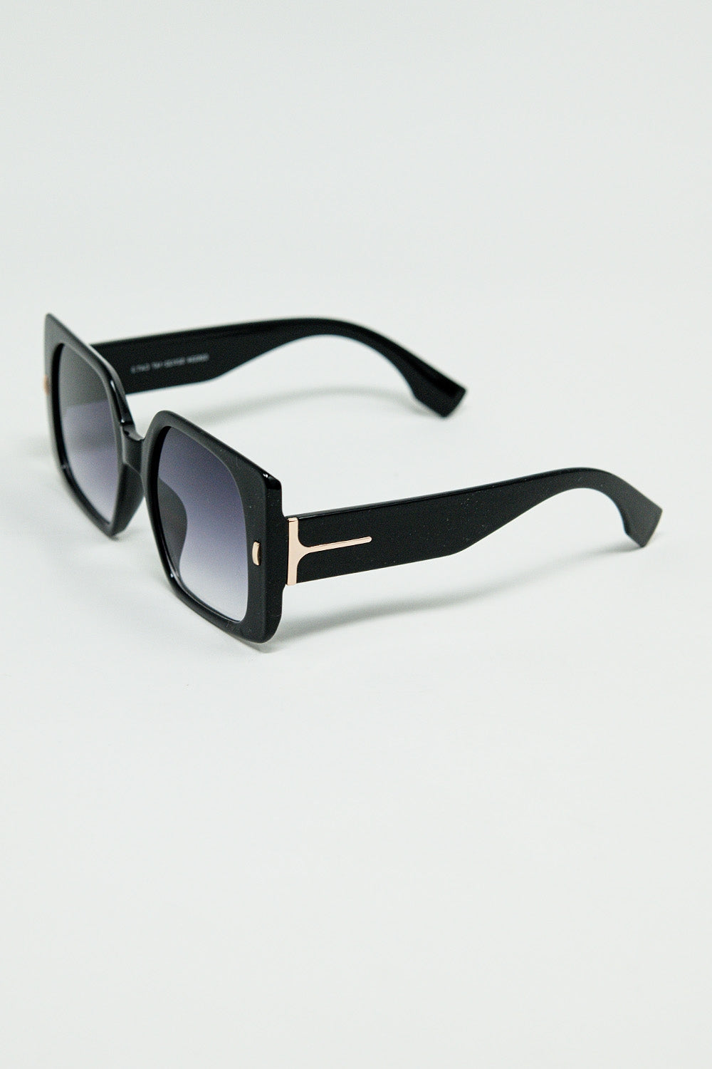Gafas de sol cuadradas negras con detalle dorado en el lateral