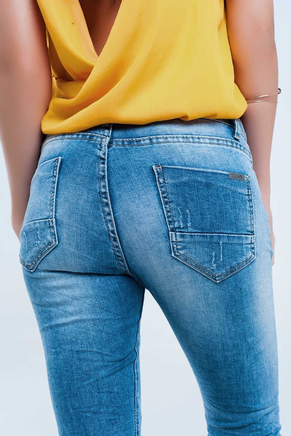 Jeans pitillo en lavado medio con rotos en las rodillas