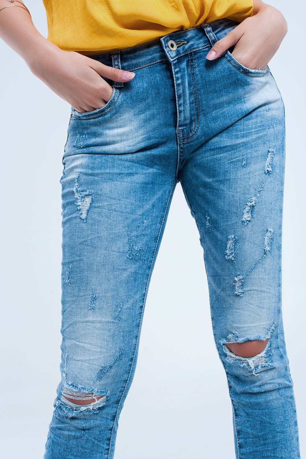 Jeans pitillo en lavado medio con rotos en las rodillas