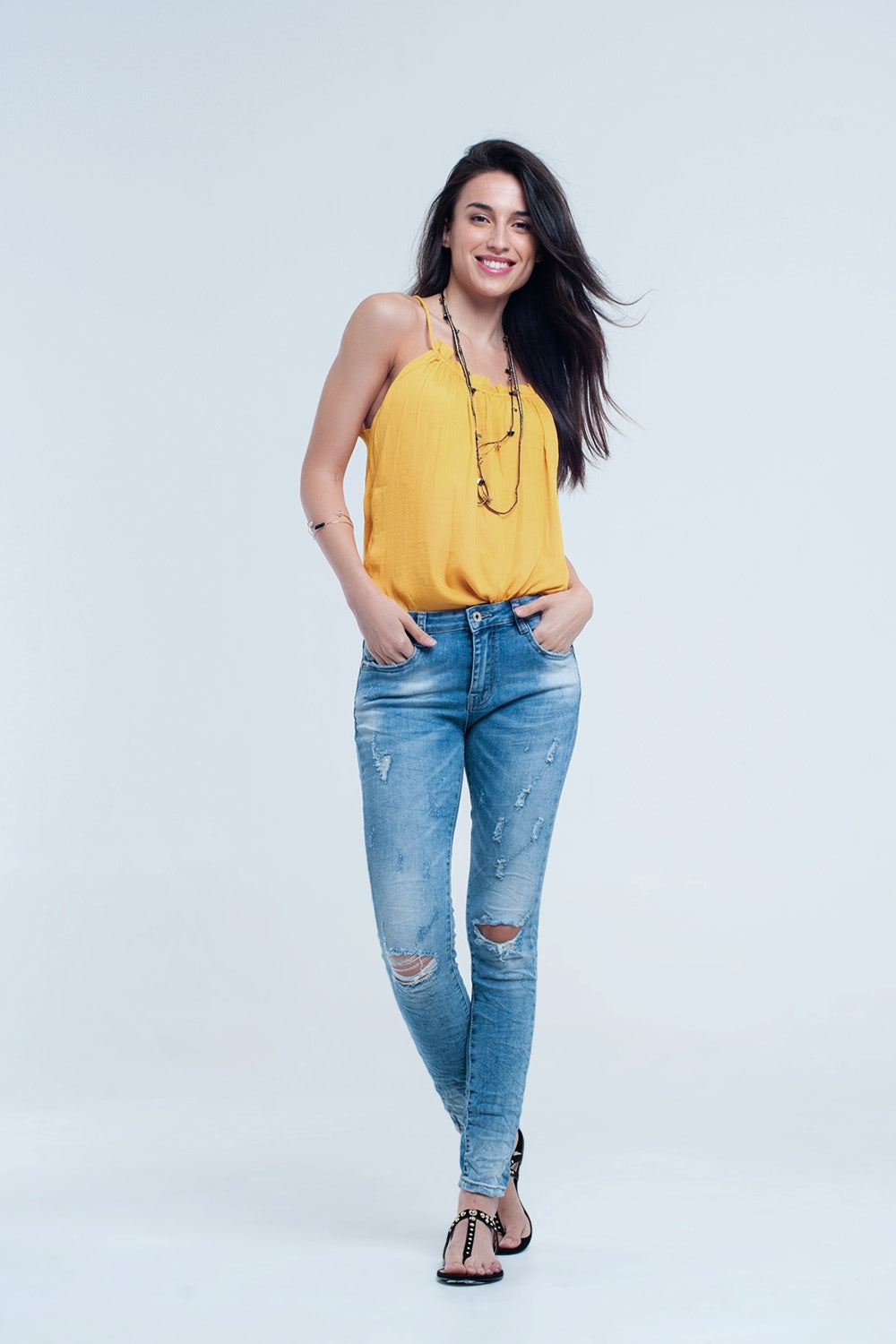 Jeans pitillo en lavado medio con rotos en las rodillas