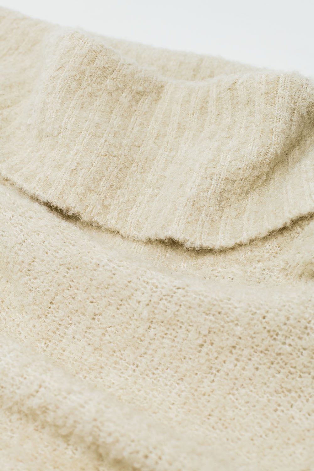 jersey de punto con cuello barco en color crema
