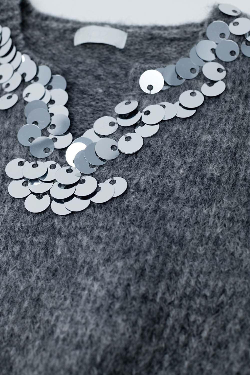 Jersey gris con cuello de pico y detalle de lentejuelas