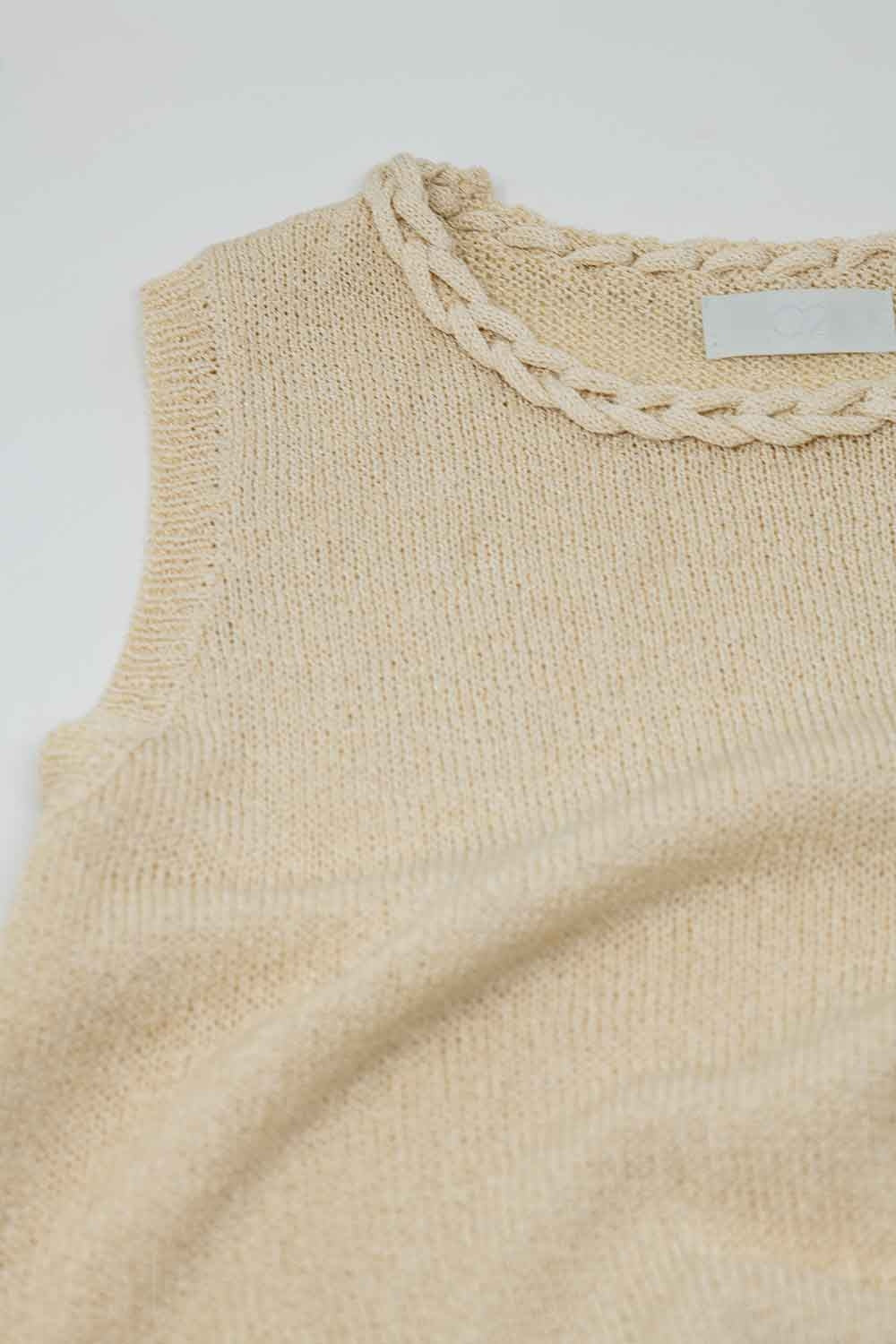 Jersey sin mangas en color beige con escote redondo y detalle de trenza en el cuello