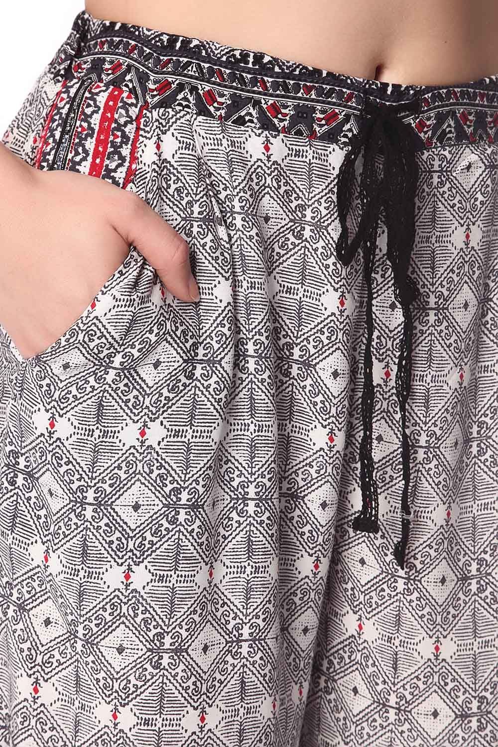 Pantalones de pernera amplia con estampado etnico negro y detalle de puntilla