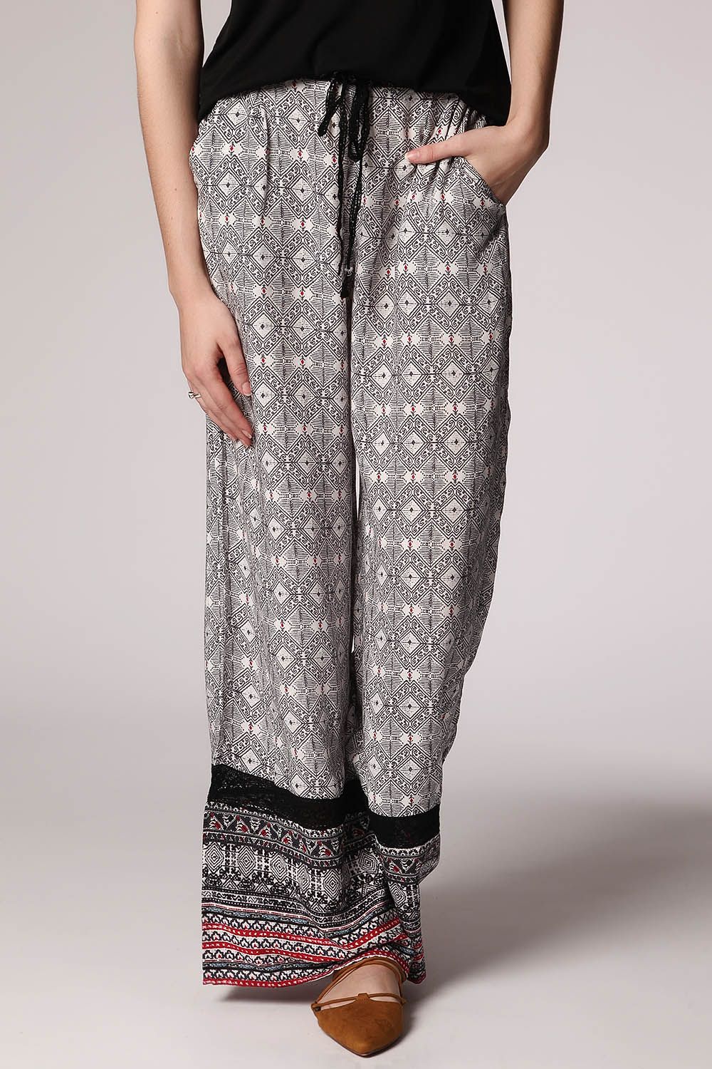 Pantalones de pernera amplia con estampado etnico negro y detalle de puntilla
