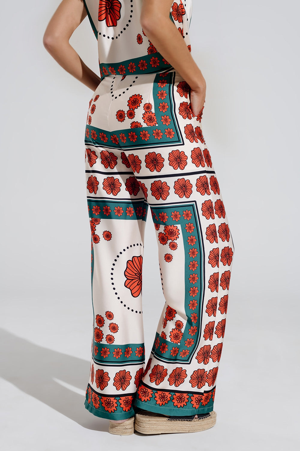 Pantalones de raso acampanados crema con diseño floral