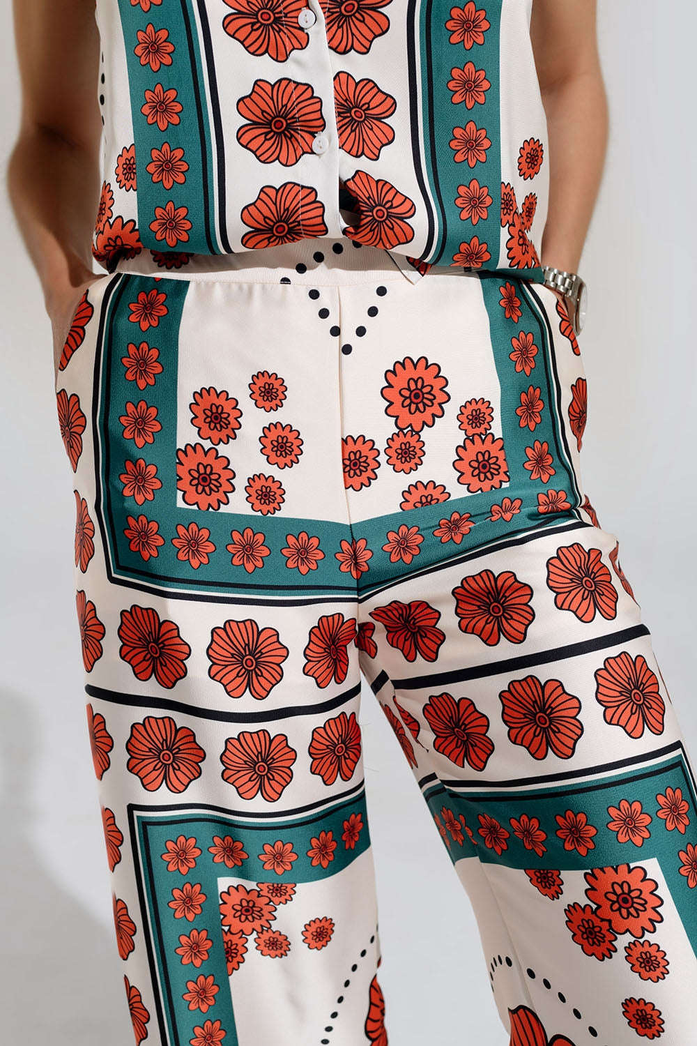 Pantalones de raso acampanados crema con diseño floral