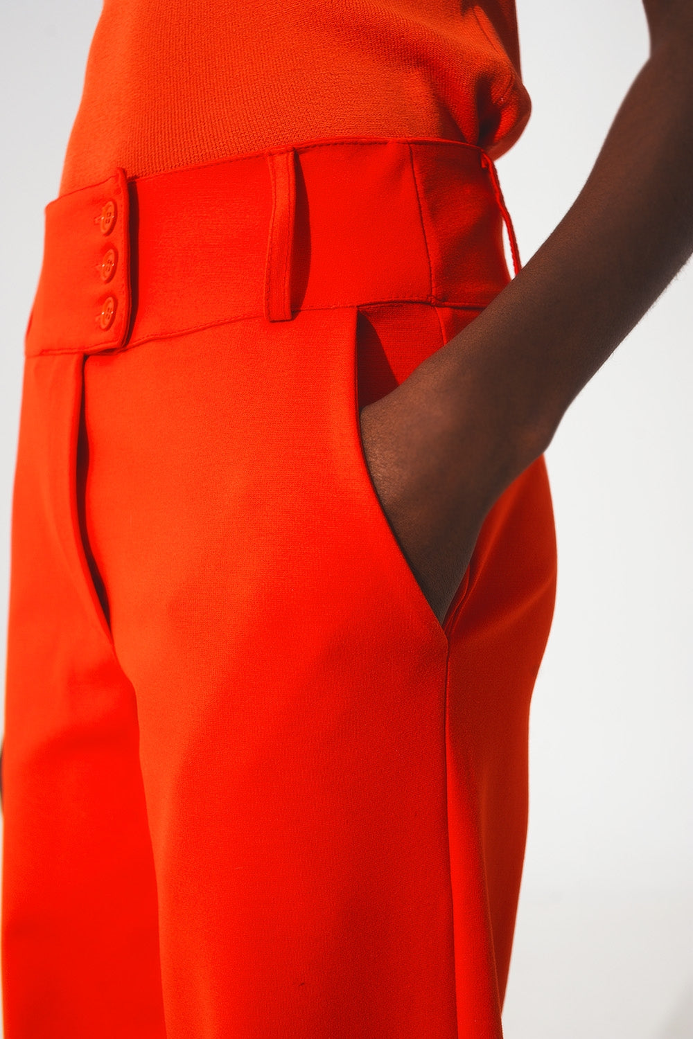 Pantalones naranja de pernera ancha y detalle de botones
