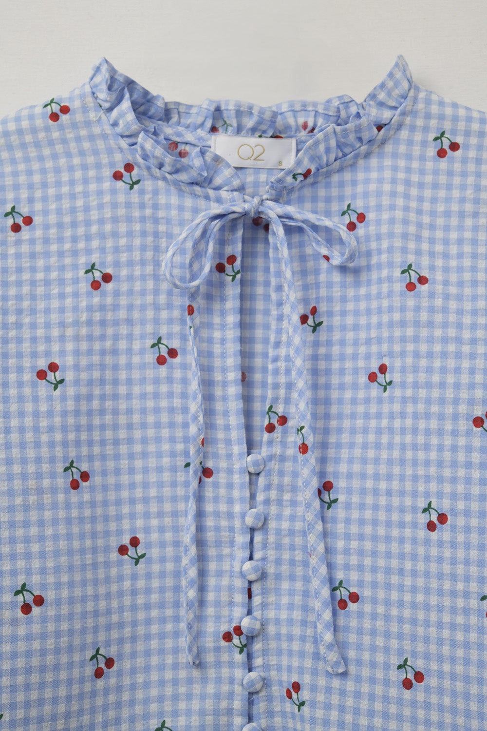 Blusa azul claro con detalles de cerezas y lazo anudado
