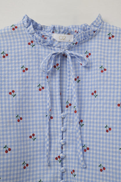 Blusa azul claro con detalles de cerezas y lazo anudado