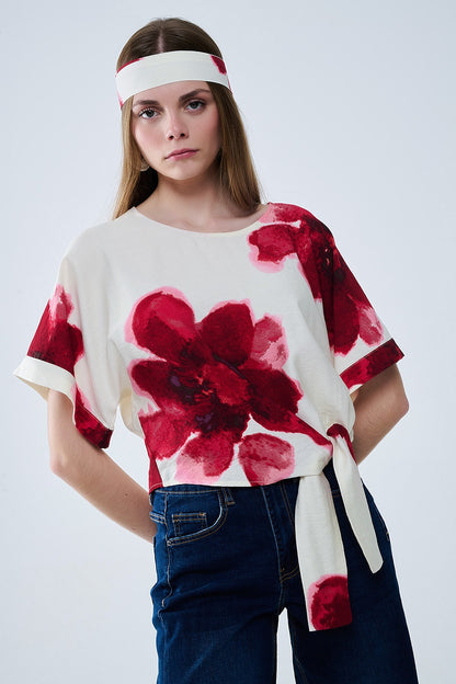 Blusa beige recortada con estampado floral tropical en rojo anudada a la cintura