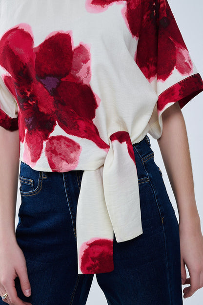 Blusa beige recortada con estampado floral tropical en rojo anudada a la cintura
