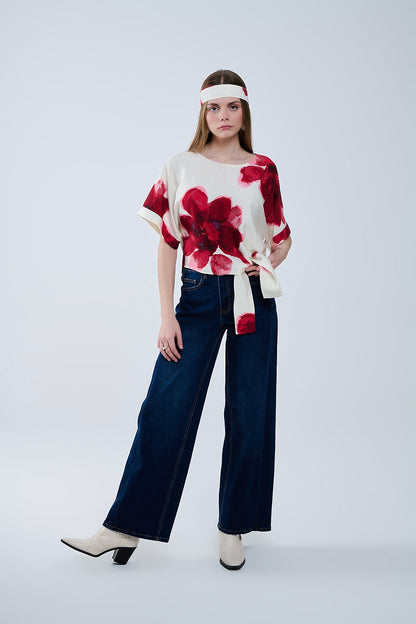 Blusa beige recortada con estampado floral tropical en rojo anudada a la cintura
