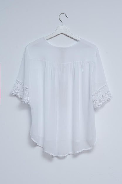 Blusa blanca con lazadas en la parte delantera y bordados