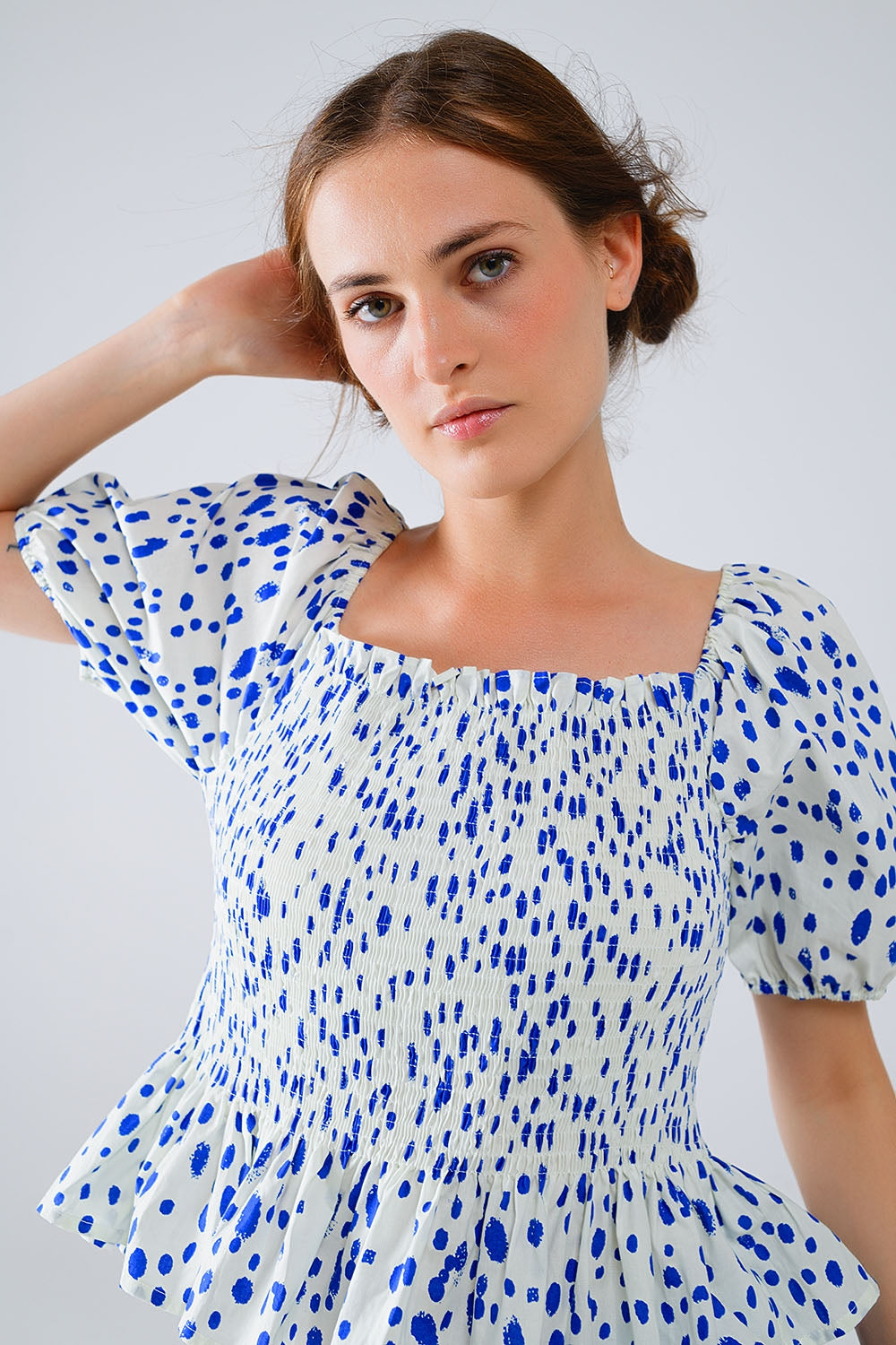 Blusa blanca con pliegues y lunares azules
