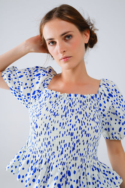 Blusa blanca con pliegues y lunares azules