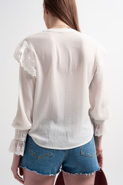 Blusa con volumen en las mangas y volantes en los puños en color crema