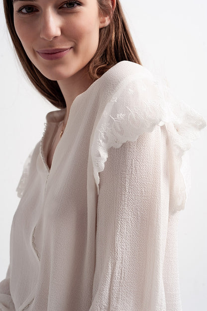 Blusa con volumen en las mangas y volantes en los puños en color crema