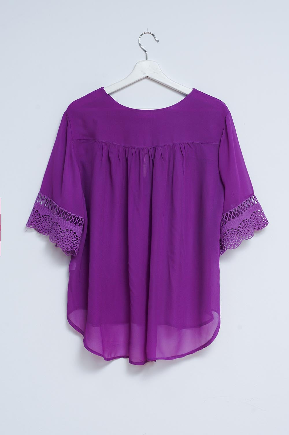 Blusa morada con lazadas en la parte delantera y bordados