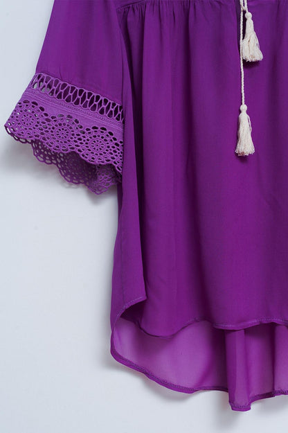 Blusa morada con lazadas en la parte delantera y bordados