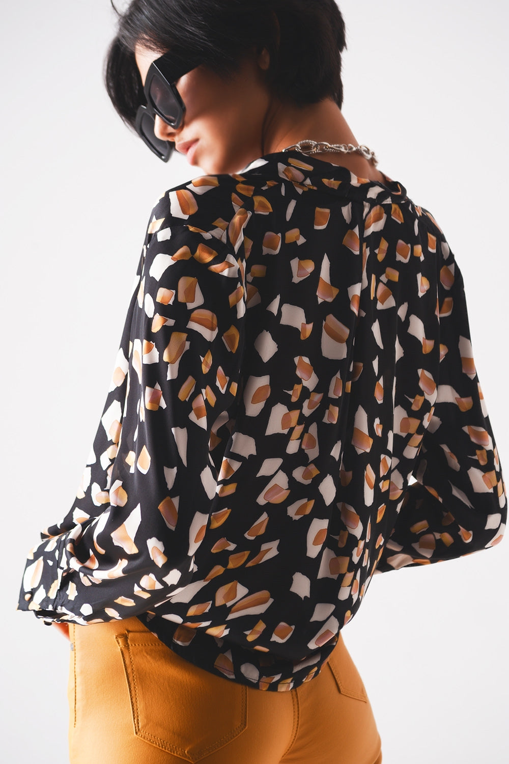 Blusa negra con estampado y parte delantera cruzada