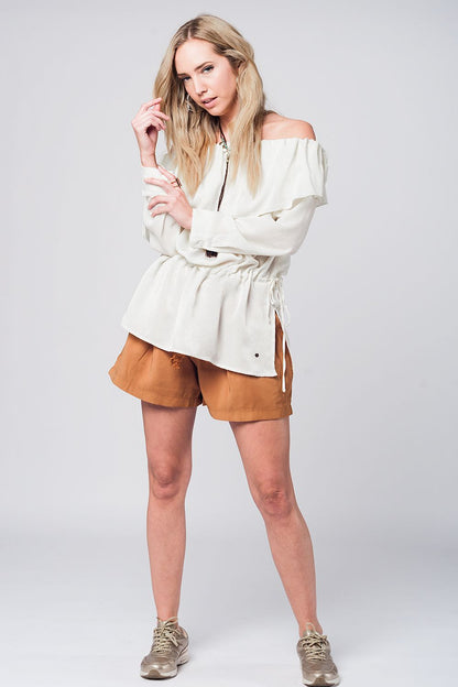 Blusa suave beige con volante y cinturón
