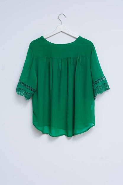 Blusa verde con lazadas en la parte delantera y bordados