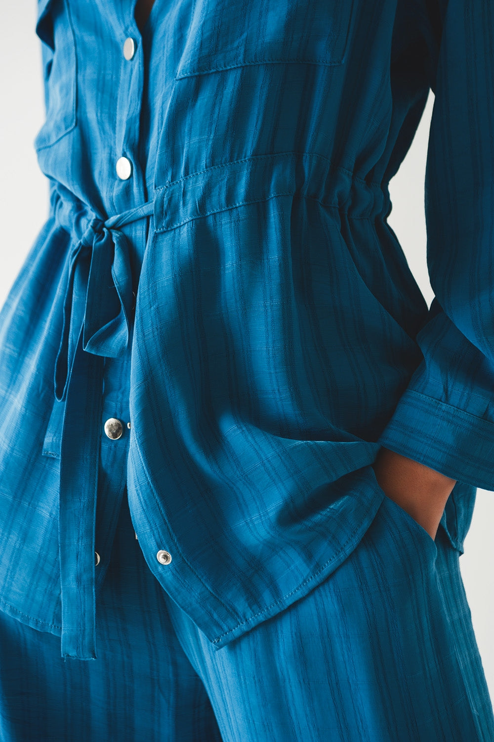 Camisa azul de manga larga con lazada en la cintura
