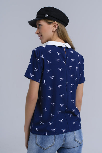Camisa azul marino con pájaros estampados blancos