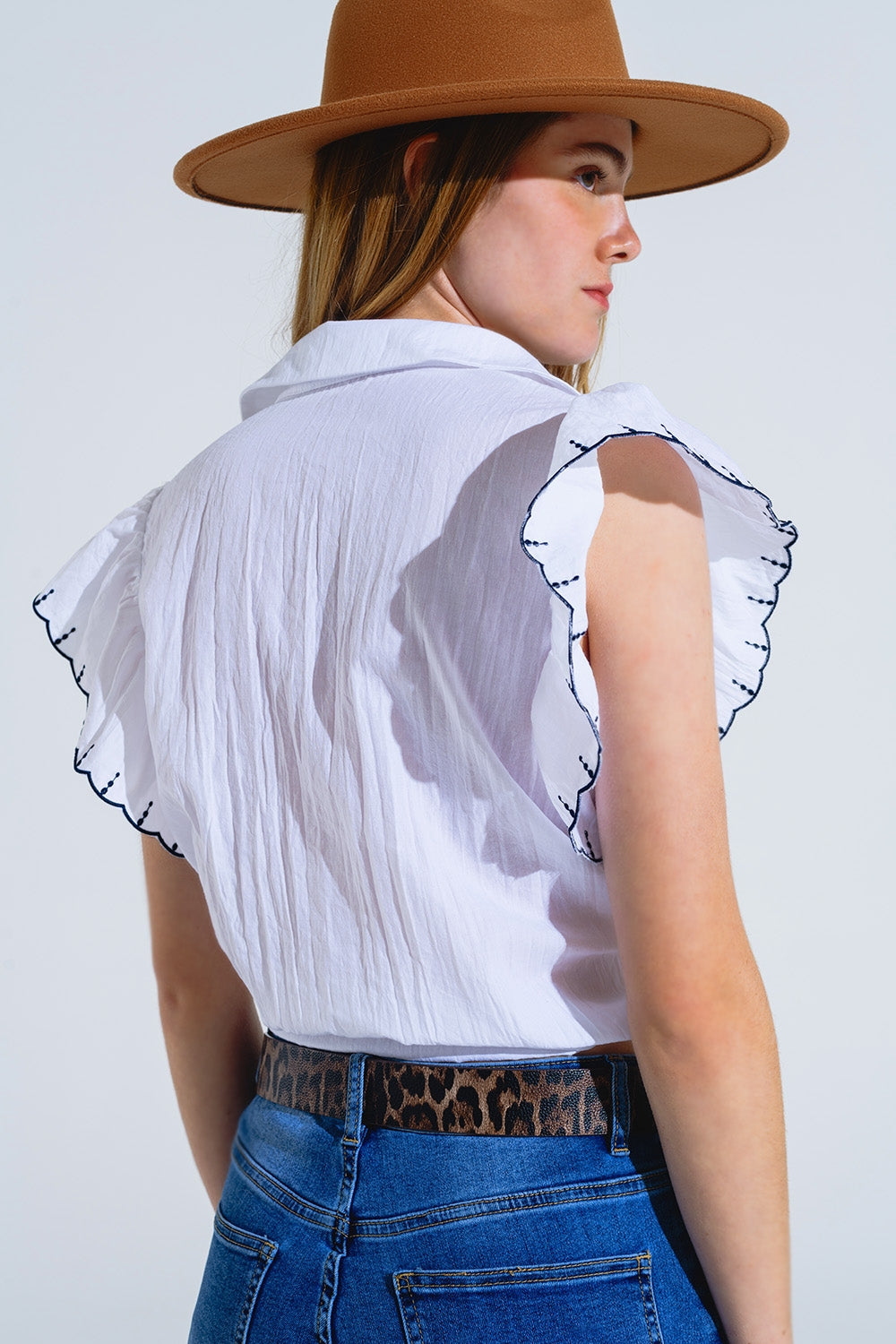 Camisa blanca abotonada con cuello de polo y mangas de volantes con ribete negro