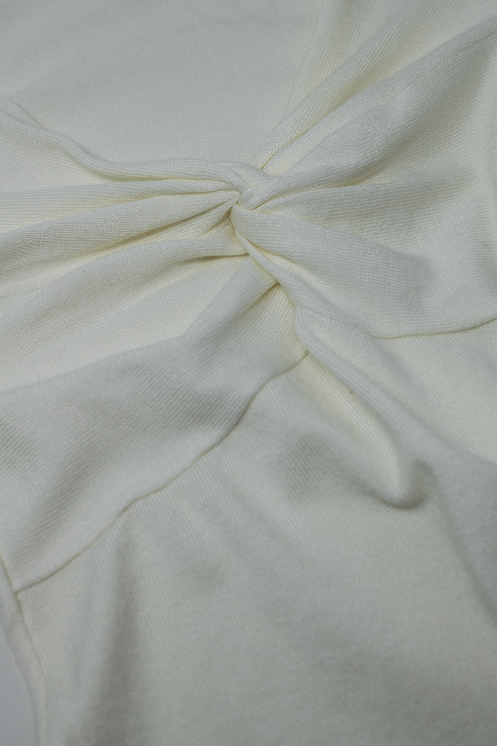 Camisa blanca de manga larga con detalle de nudo y cuello de pico
