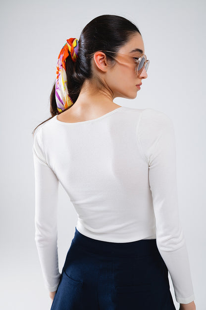 Camisa blanca de manga larga con detalle de nudo y cuello de pico