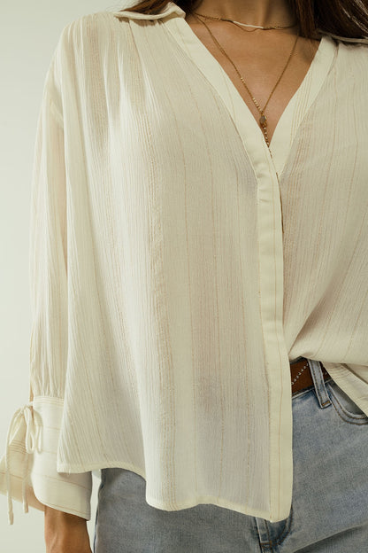 camisa blanca ligera con cuello de pico y detalles de rayas